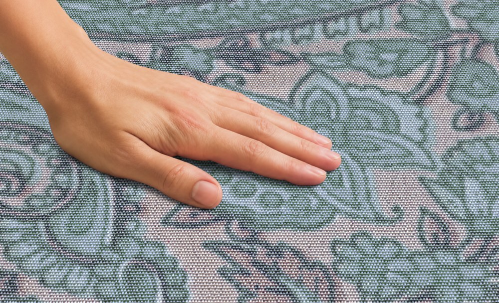 Mano apreciando la textura de una alfombra Ana Durán